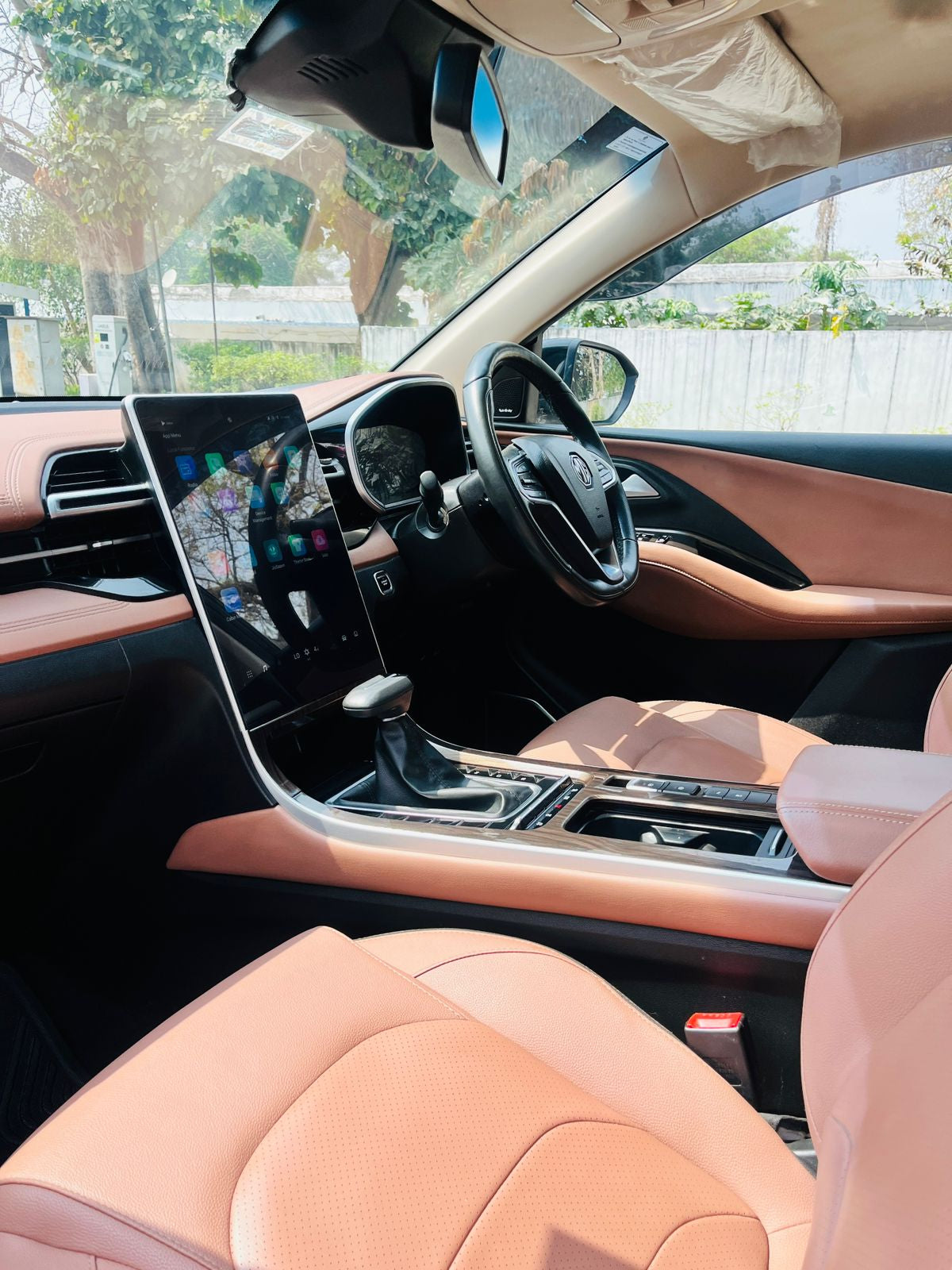 Luxury car interior with beige leather seats and modern dashboard.