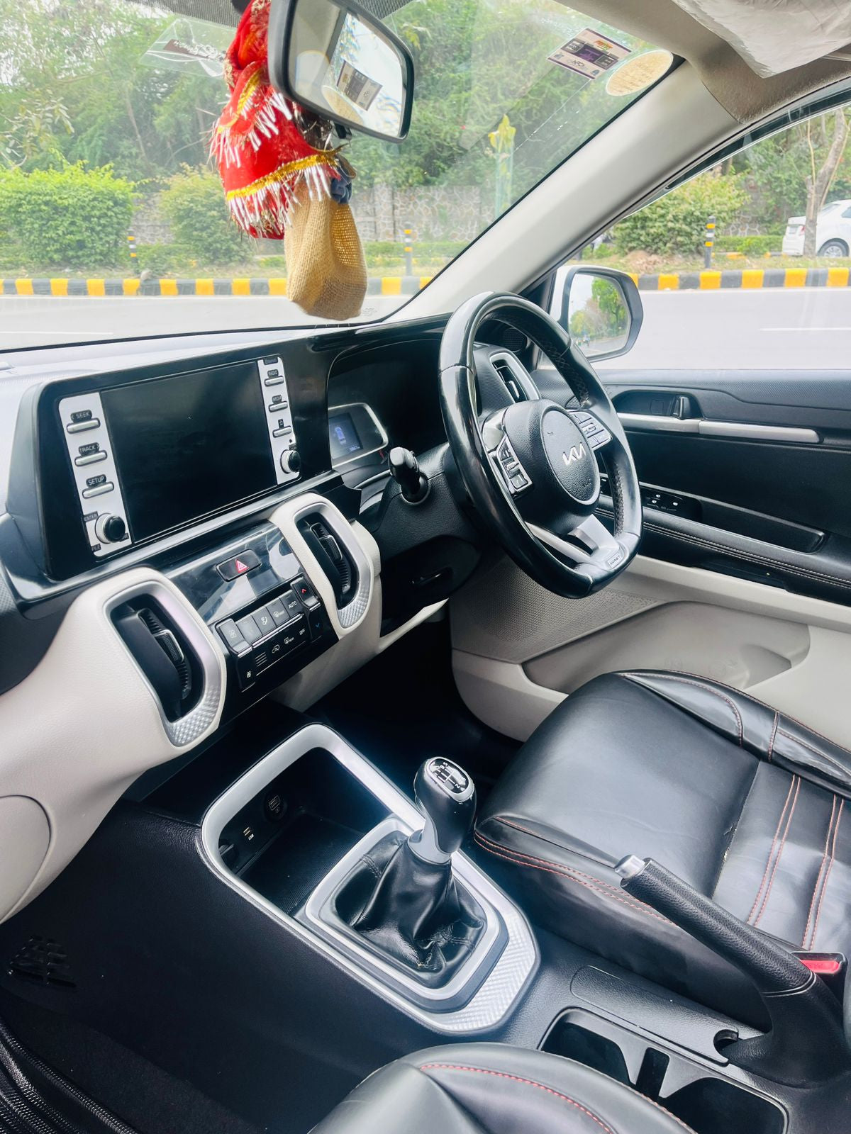 Car interior with dashboard, steering wheel, and gear shift in a vehicle.