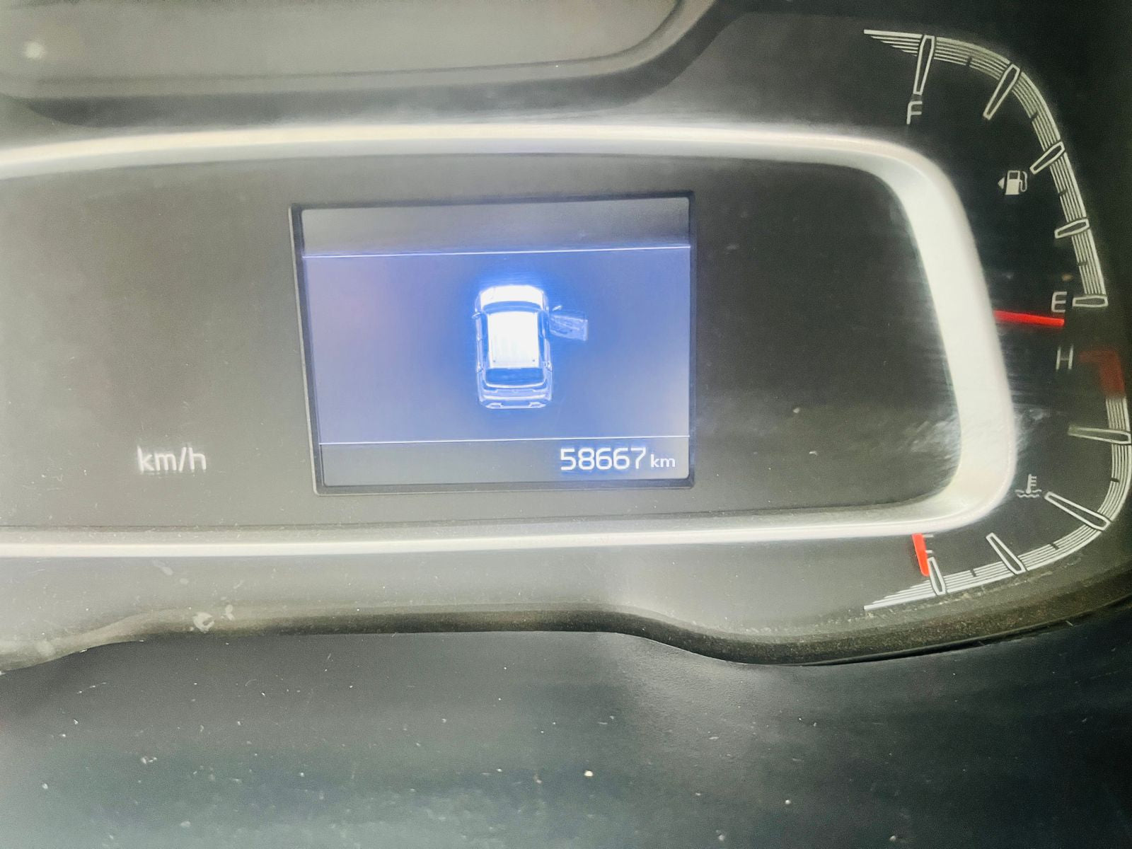 Car dashboard with digital display showing mileage and other information.