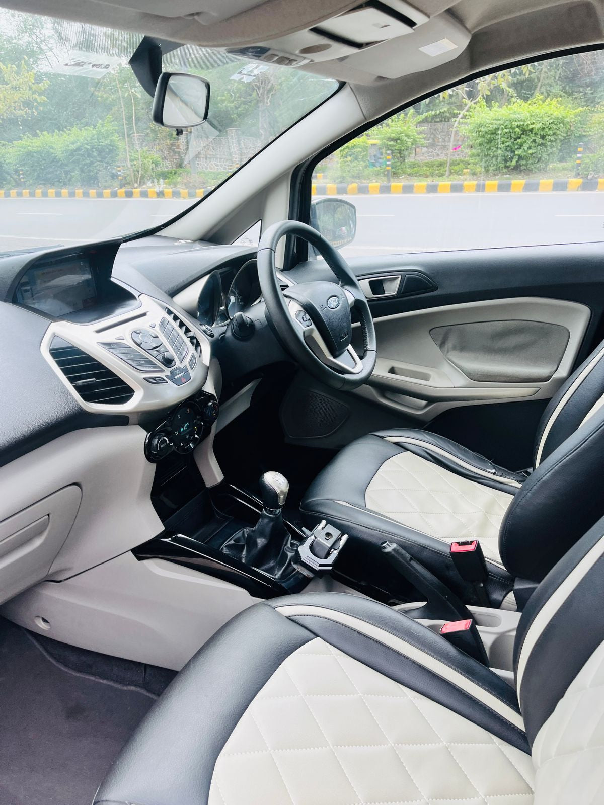 Car interior with steering wheel, dashboard, and seats.