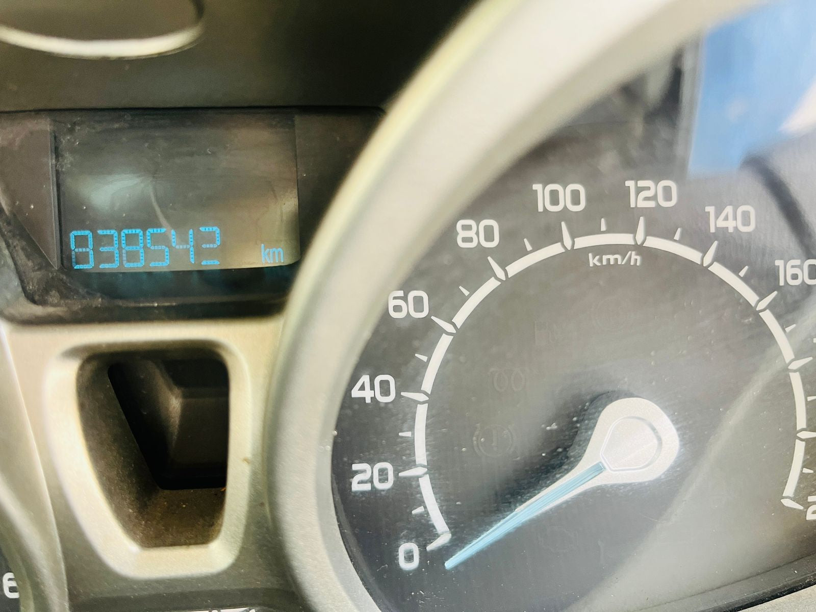 Car dashboard with speedometer and digital display showing mileage.