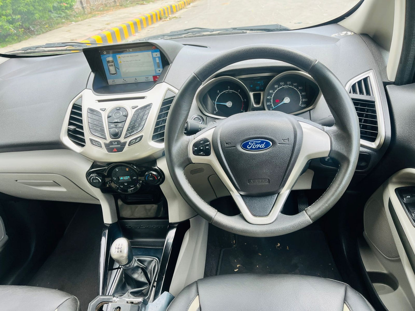 Car interior with steering wheel and dashboard, featuring a Ford logo.