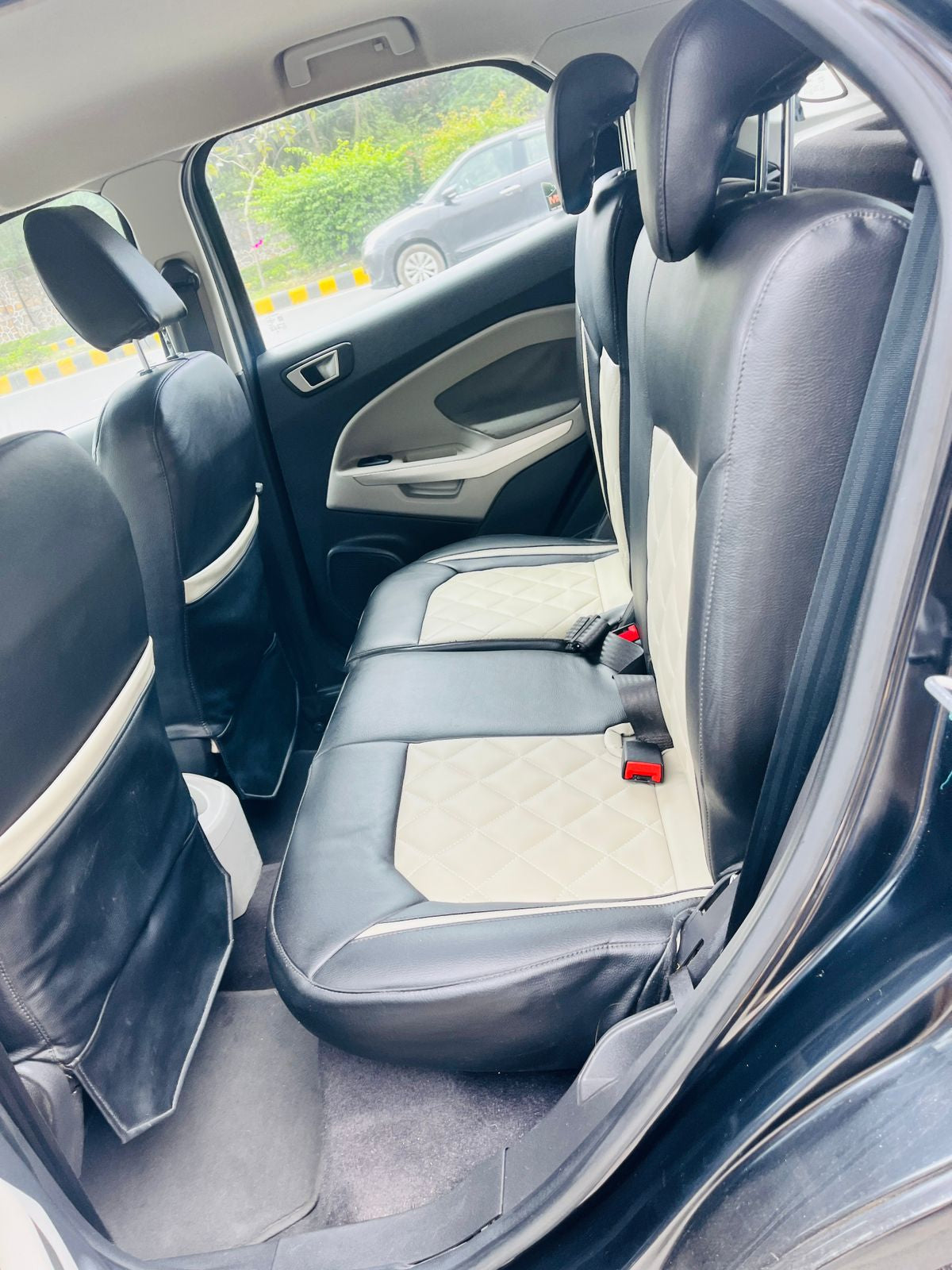 Back seat of a car with gray upholstery, showing the interior design and layout.