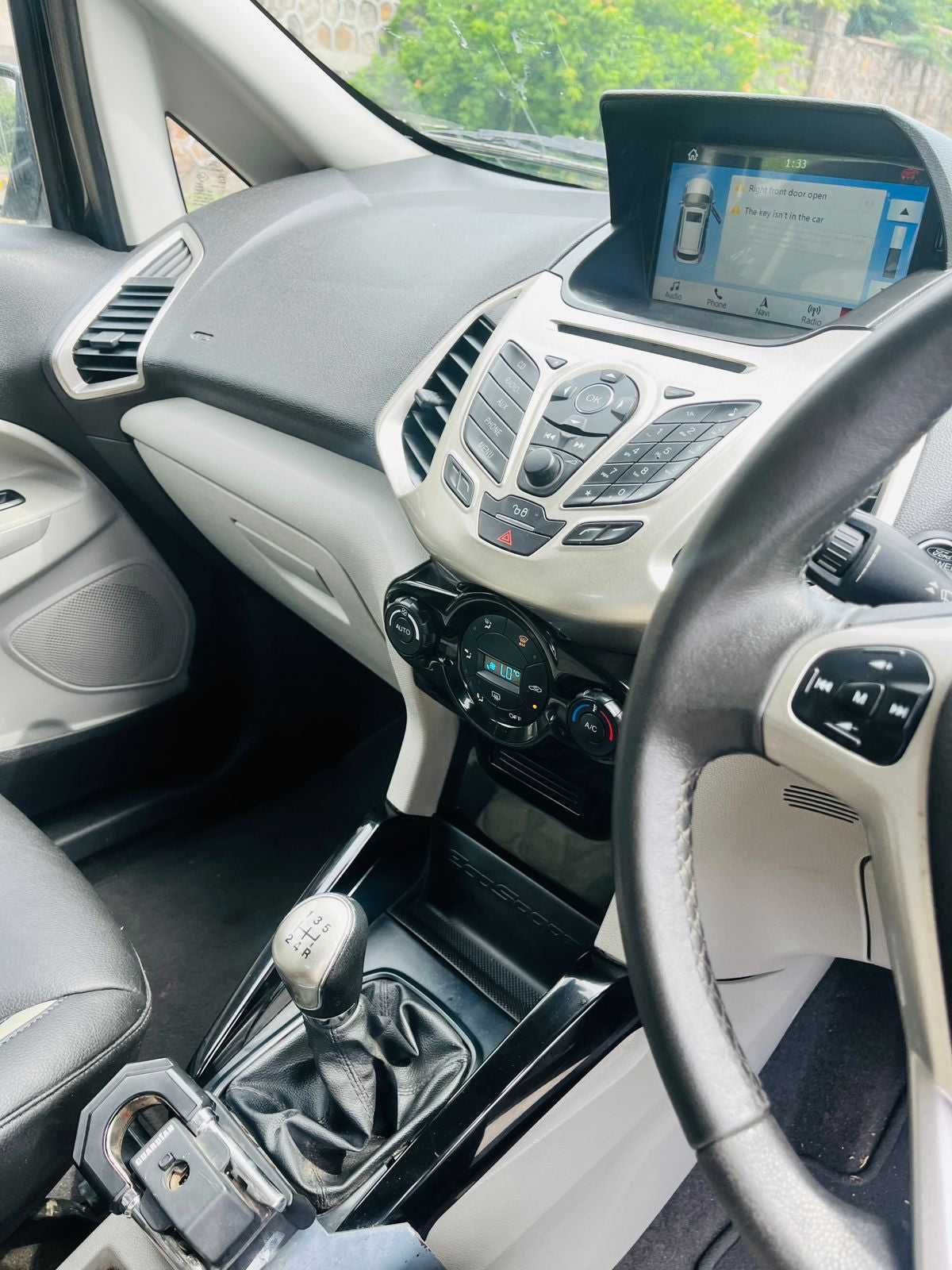 Car interior with dashboard, steering wheel, and infotainment system.
