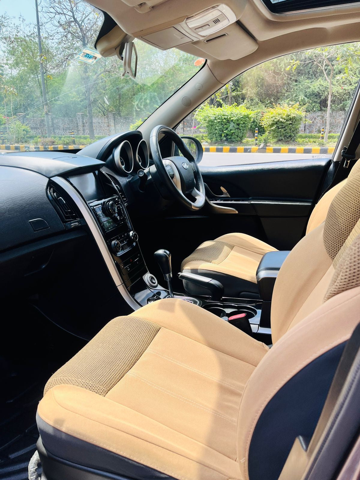 Car interior with beige seat covers and dashboard view