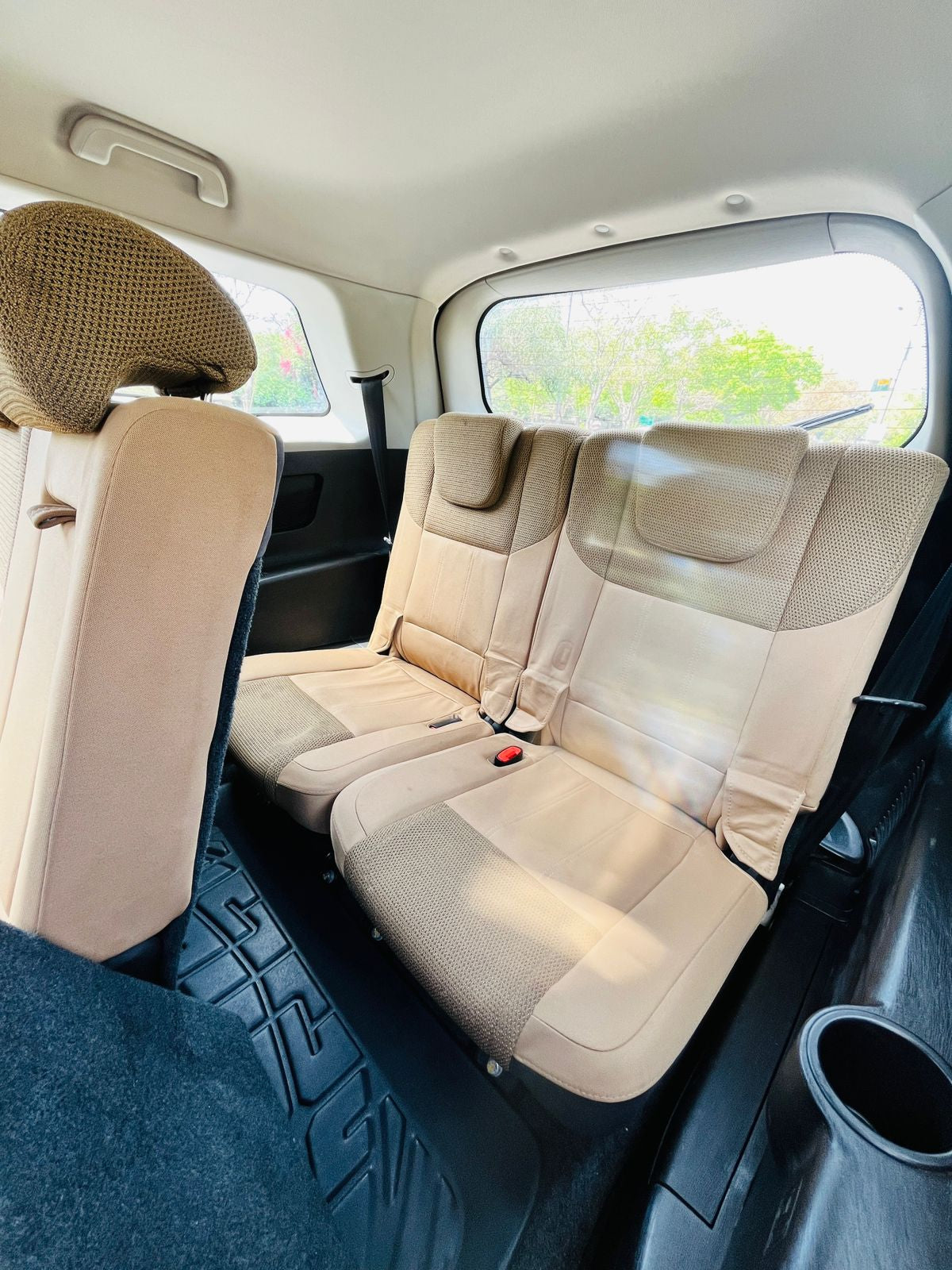 Beige car interior with three seats and a visible cargo area.