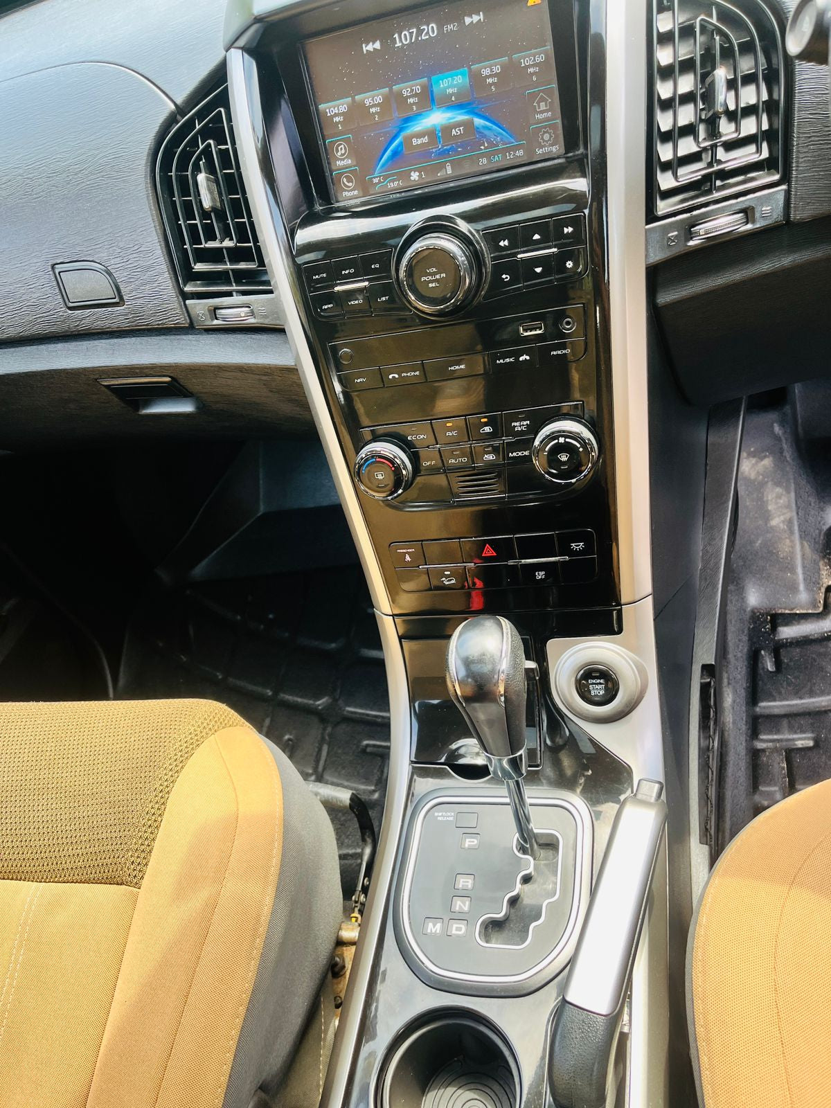 Car interior with dashboard, steering wheel, and center console.
