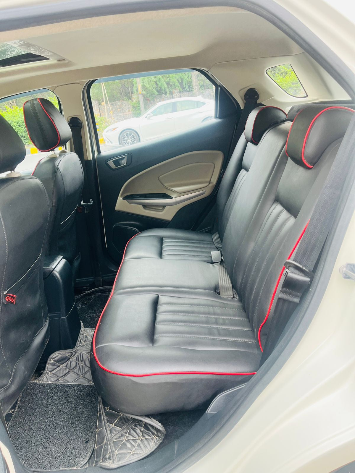 Back seat of a car with gray upholstery and red stitching