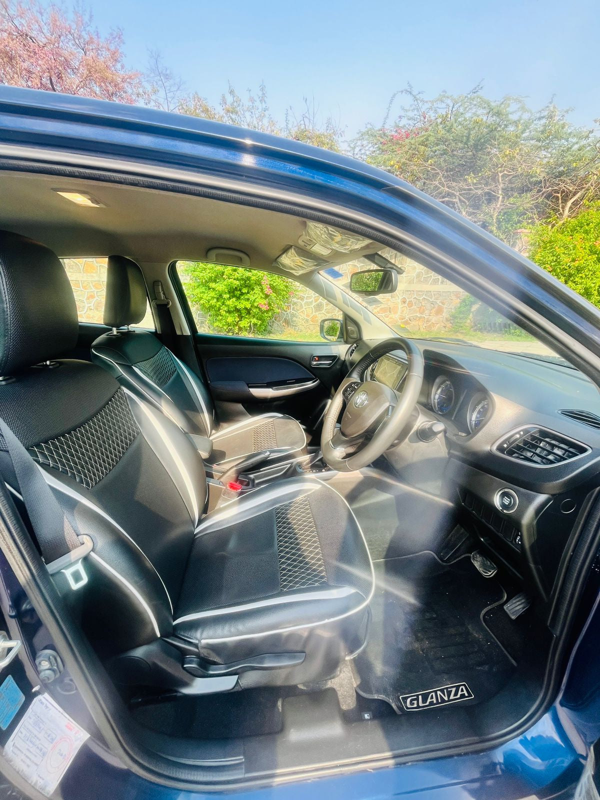 Car interior with 'Glanza' branding on a sunny day