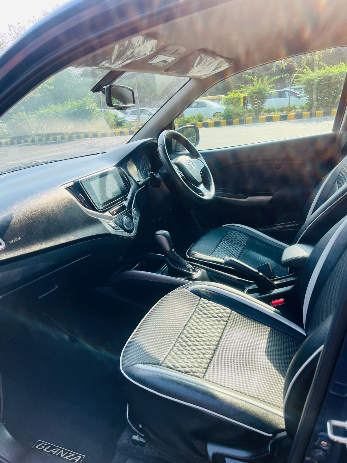 Car interior with steering wheel and dashboard, blurred background