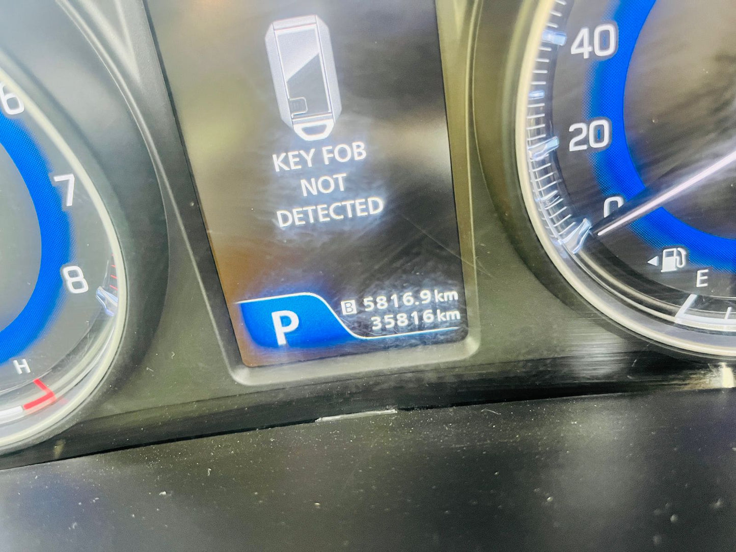 Car dashboard with key fob not detected message and mileage display.