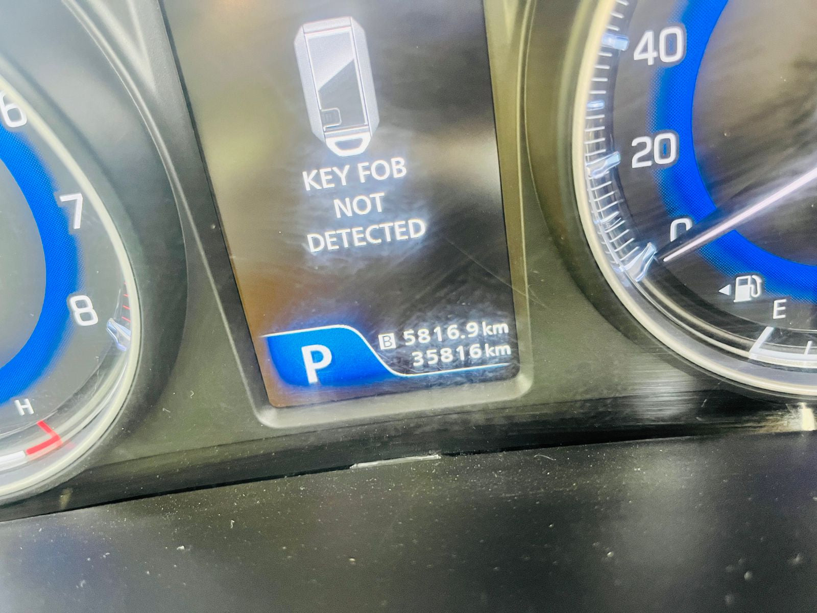 Car dashboard with key fob not detected message and mileage display.