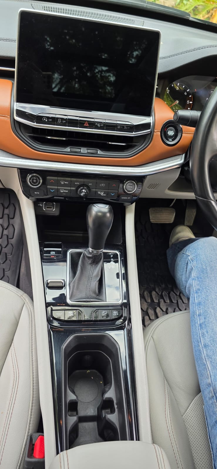 Car interior with center console, gear shift, and dashboard view.