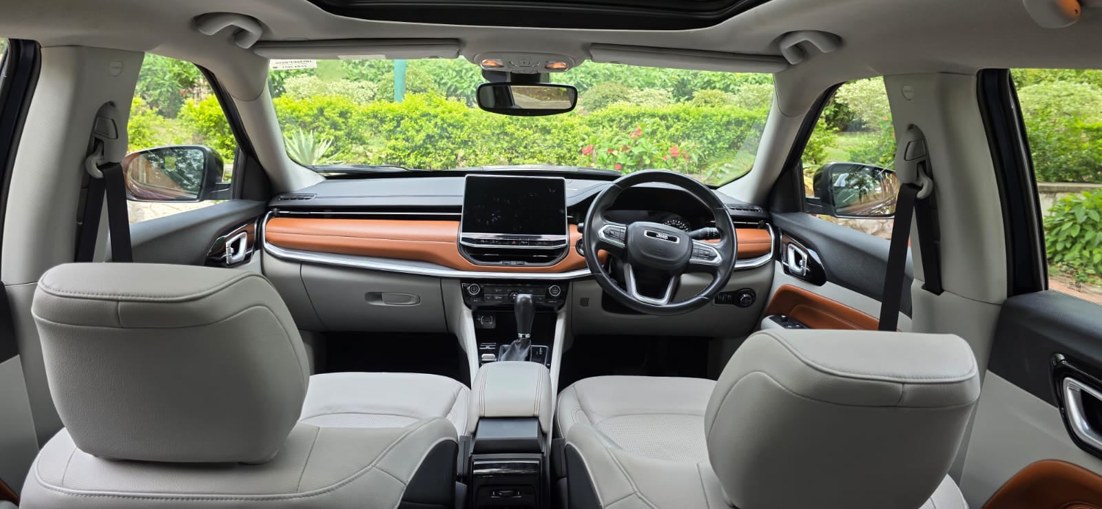 Car interior with dashboard, steering wheel, and front seats.