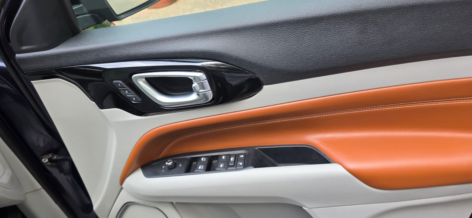 Close-up of a car's interior door panel with orange accents
