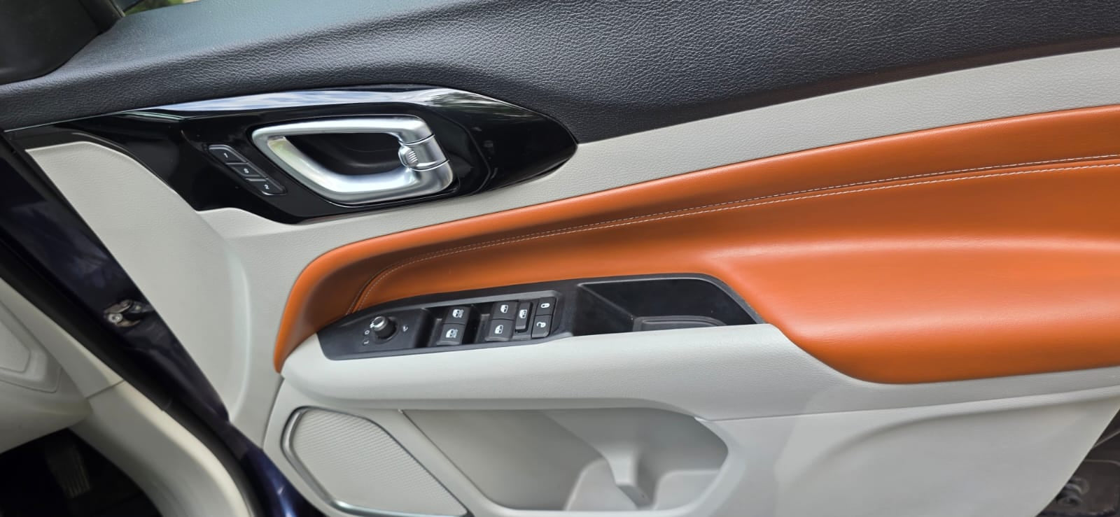 Close-up of a car's interior panel with orange accents