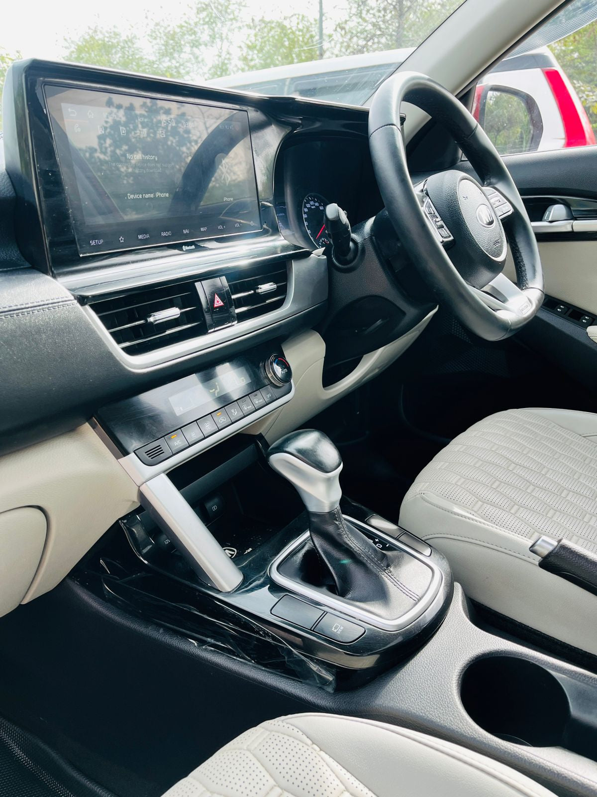Car interior with dashboard, steering wheel, and gear shift.