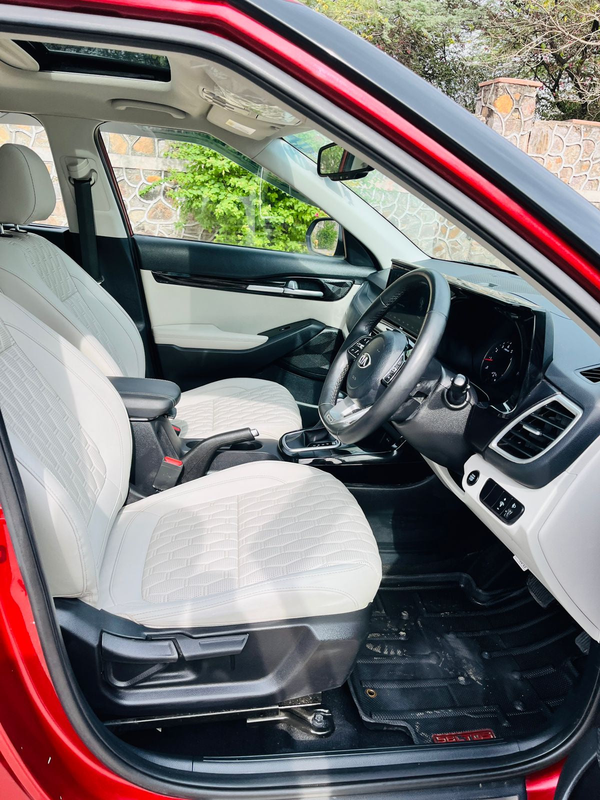 Car interior with beige seats and a red exterior