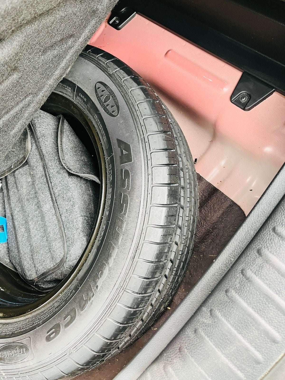 Car tire with '4C' branding on a pink car interior.