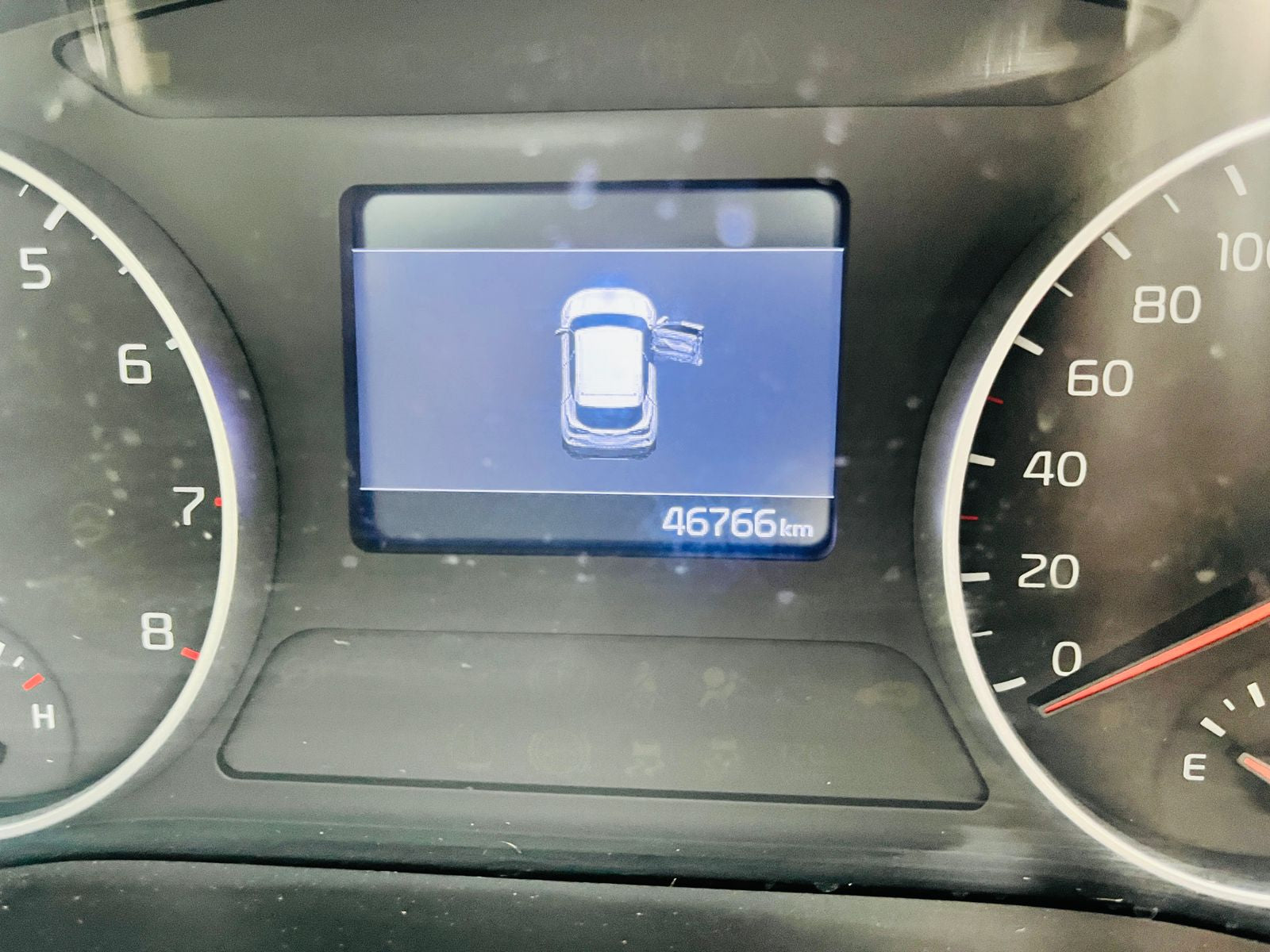 Car dashboard with digital display showing 46,766 kilometers.