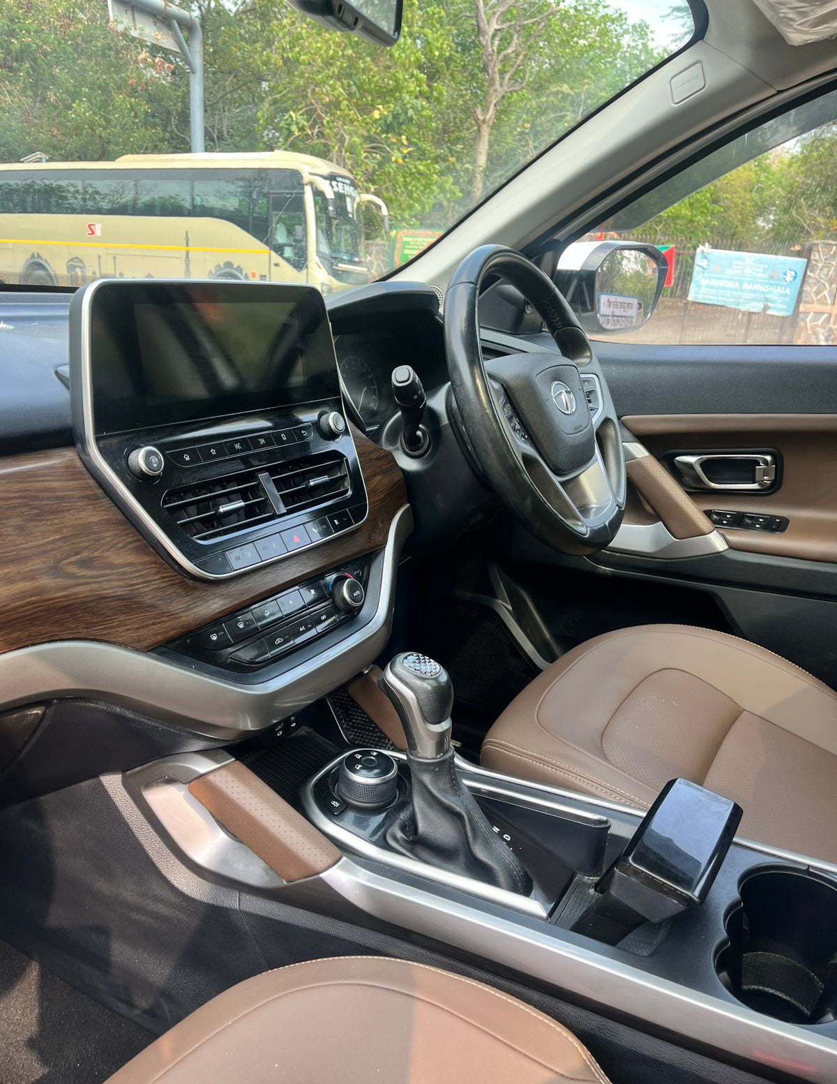 Car interior with dashboard, steering wheel, and gear shift in a vehicle.