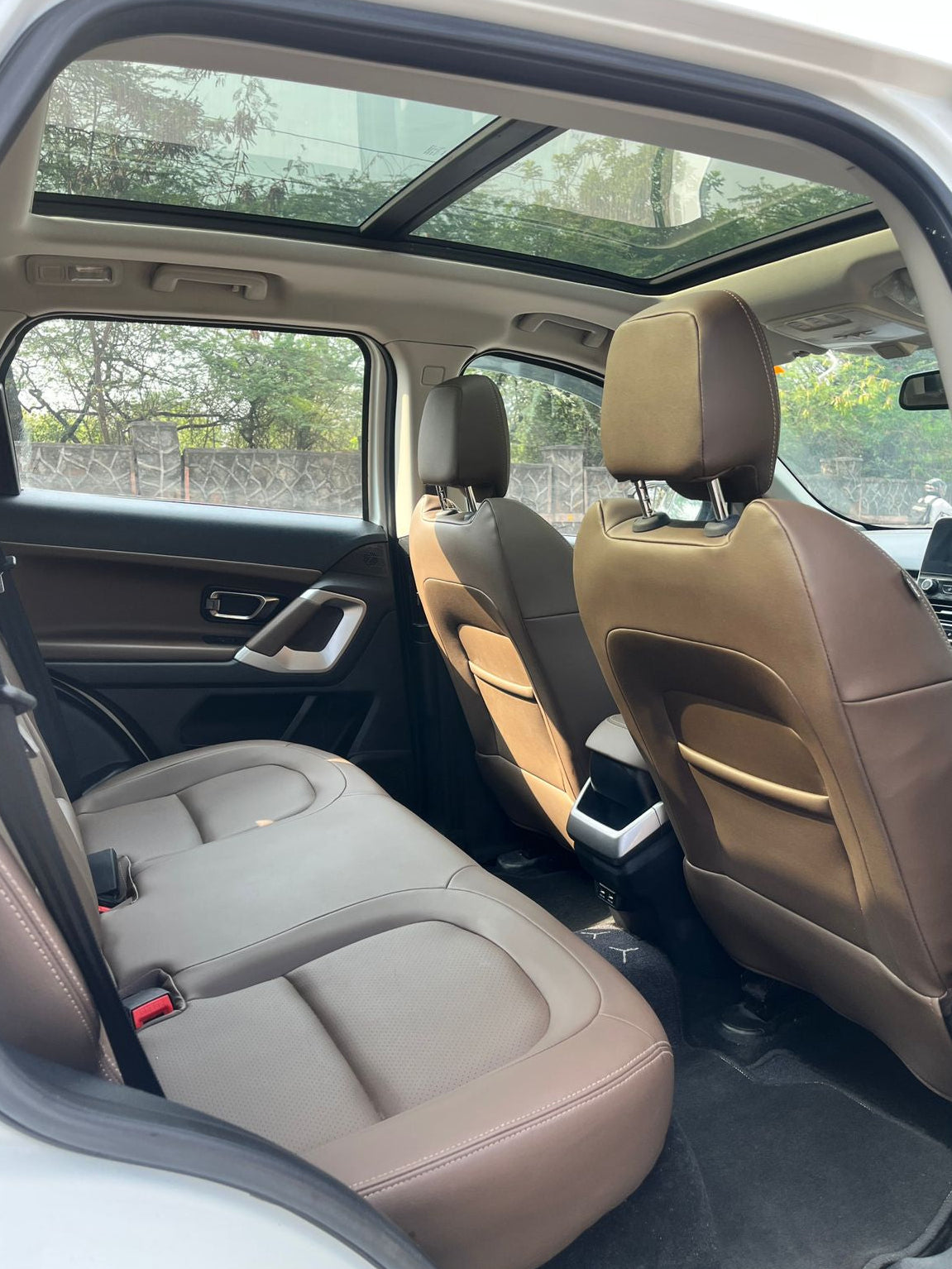 Beige interior of a car with sunroof and rear seats.