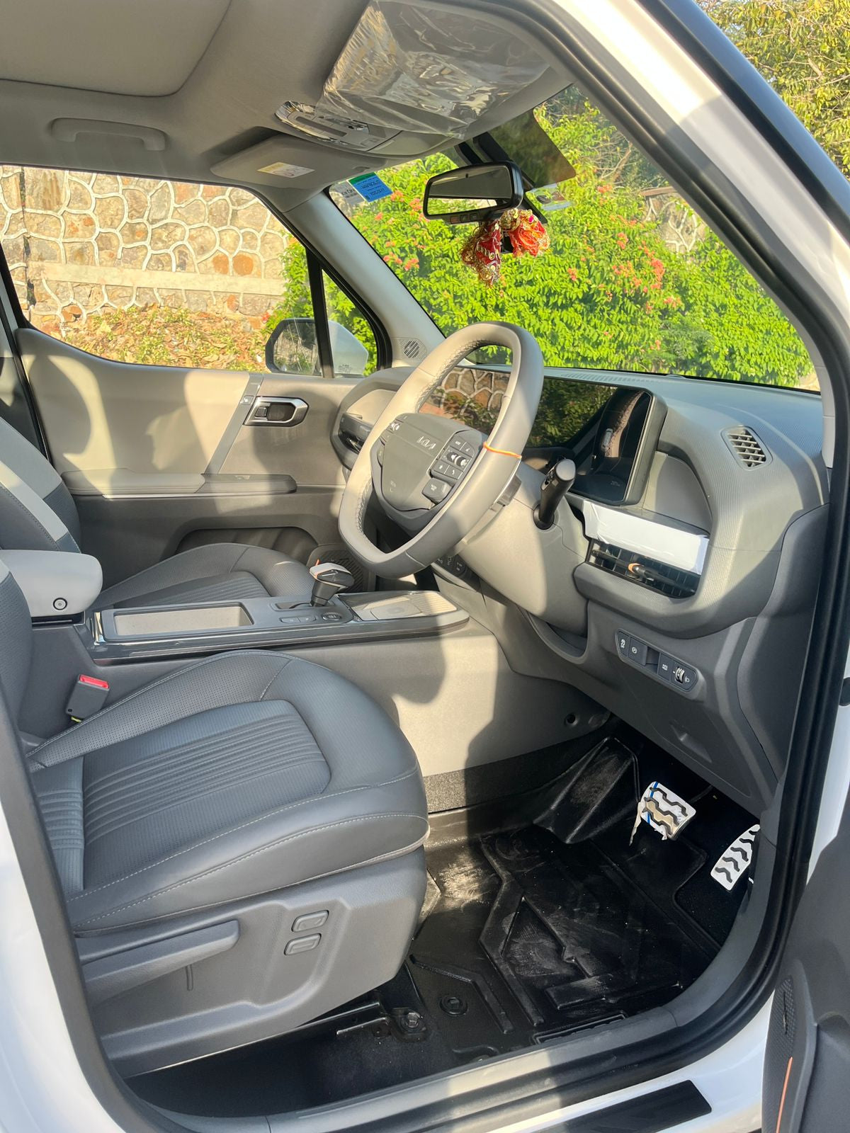 Interior of a vehicle with steering wheel, dashboard, and seats.