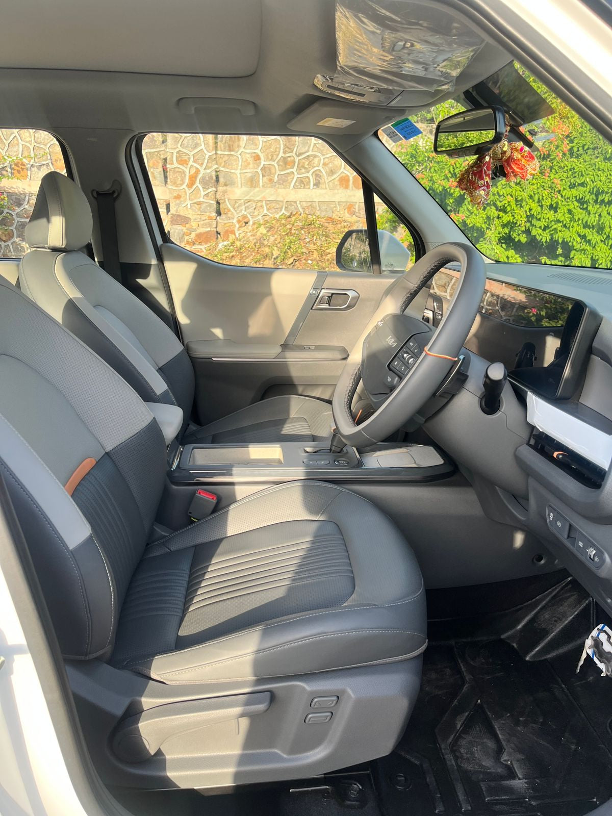Gray interior of a vehicle with visible dashboard and steering wheel.