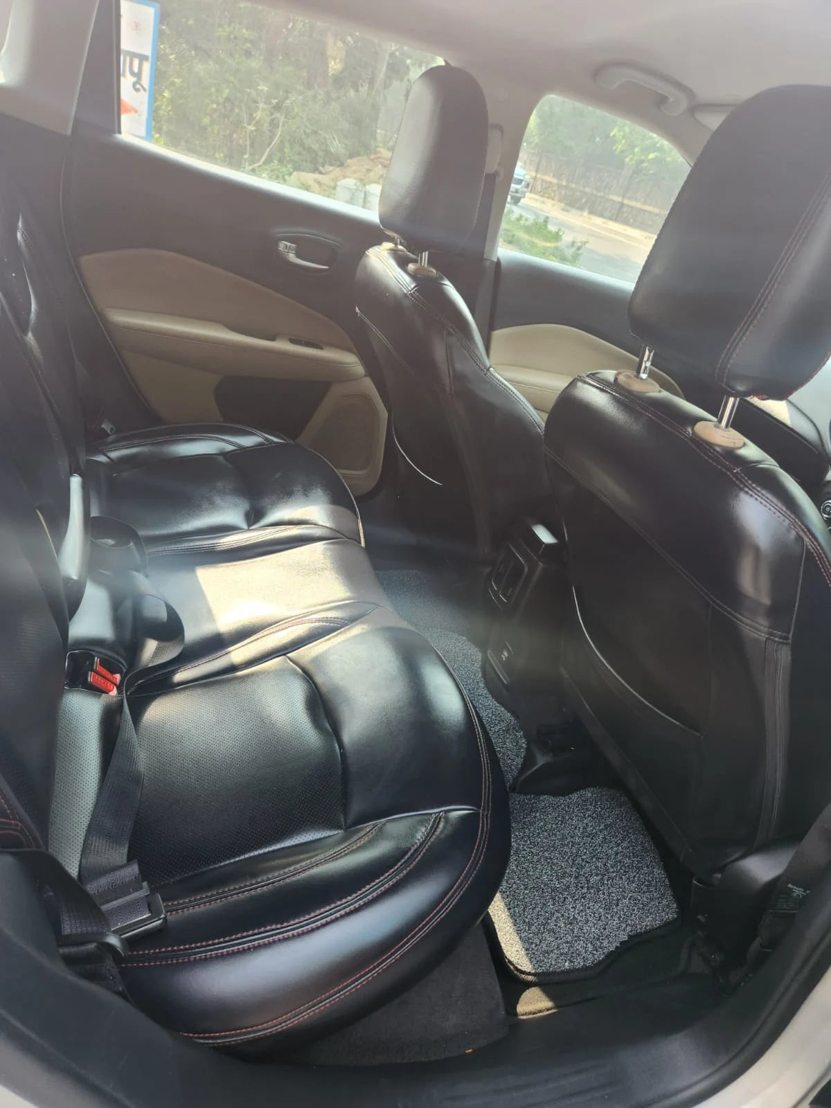 Back seat of a car with a black bag on the floor