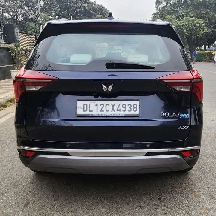 Black SUV on a road with trees and buildings in the background