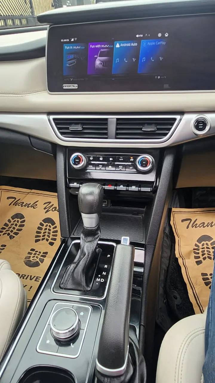 Car interior with dashboard, gear shift, and control panel.