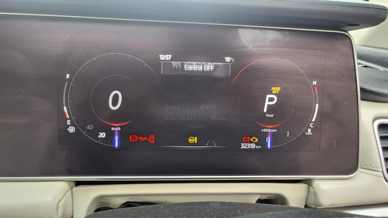 Car dashboard with digital display showing gear indicator and other controls.