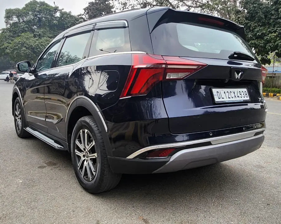 Black SUV on a road with trees in the background