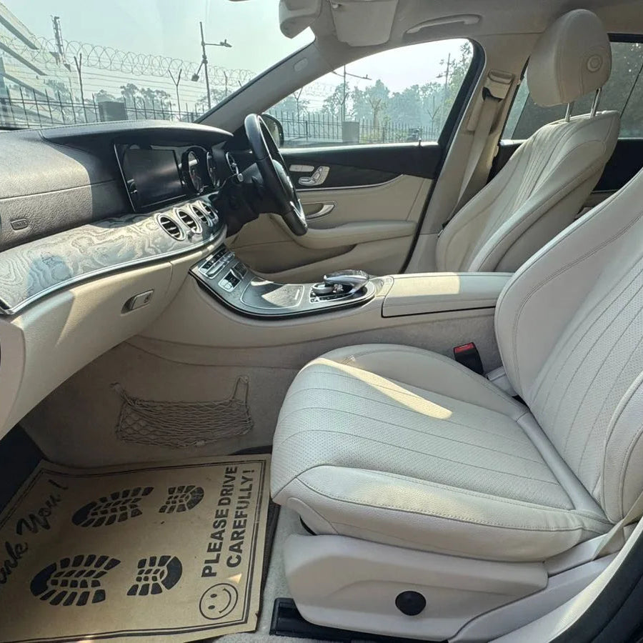 Luxury car interior with beige leather seats and dashboard.