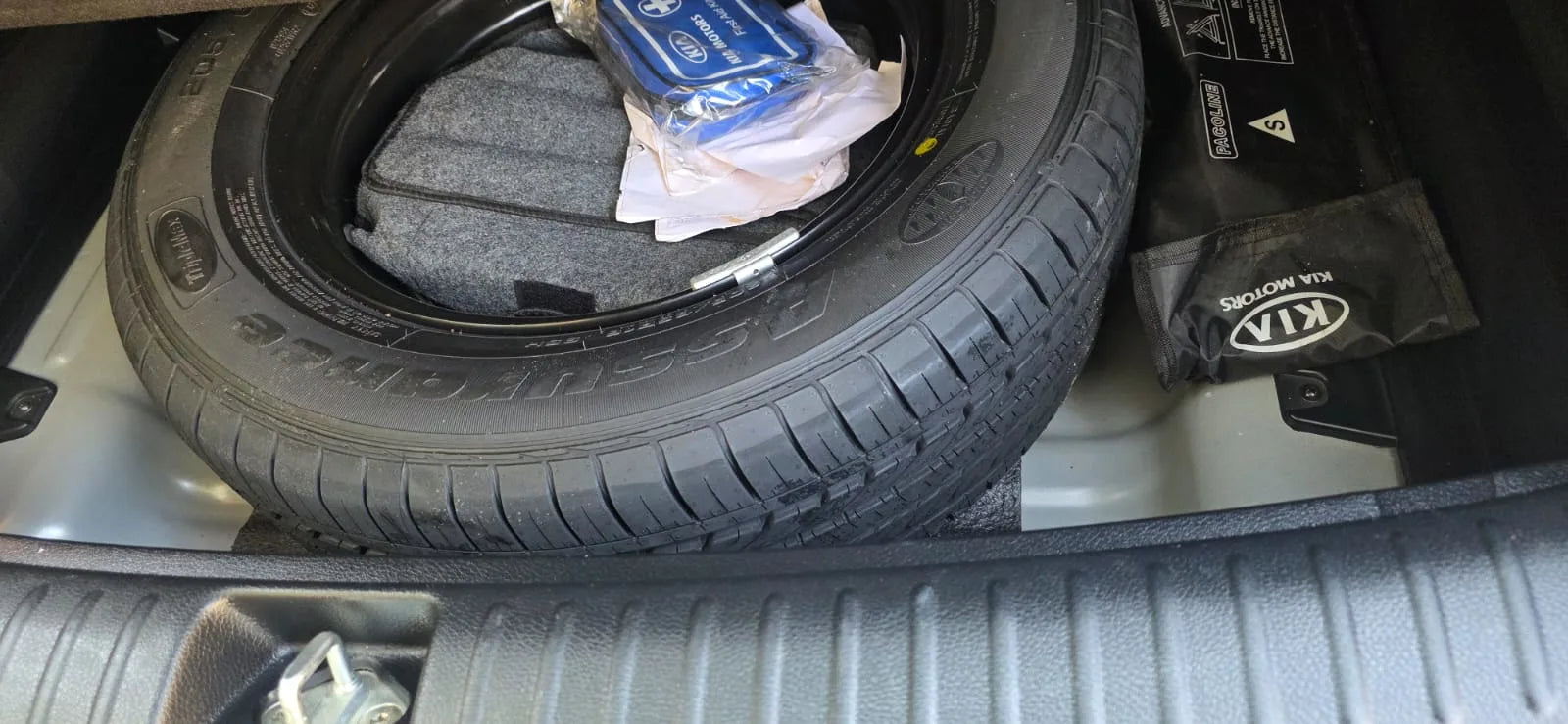 Tire in a car trunk with visible branding