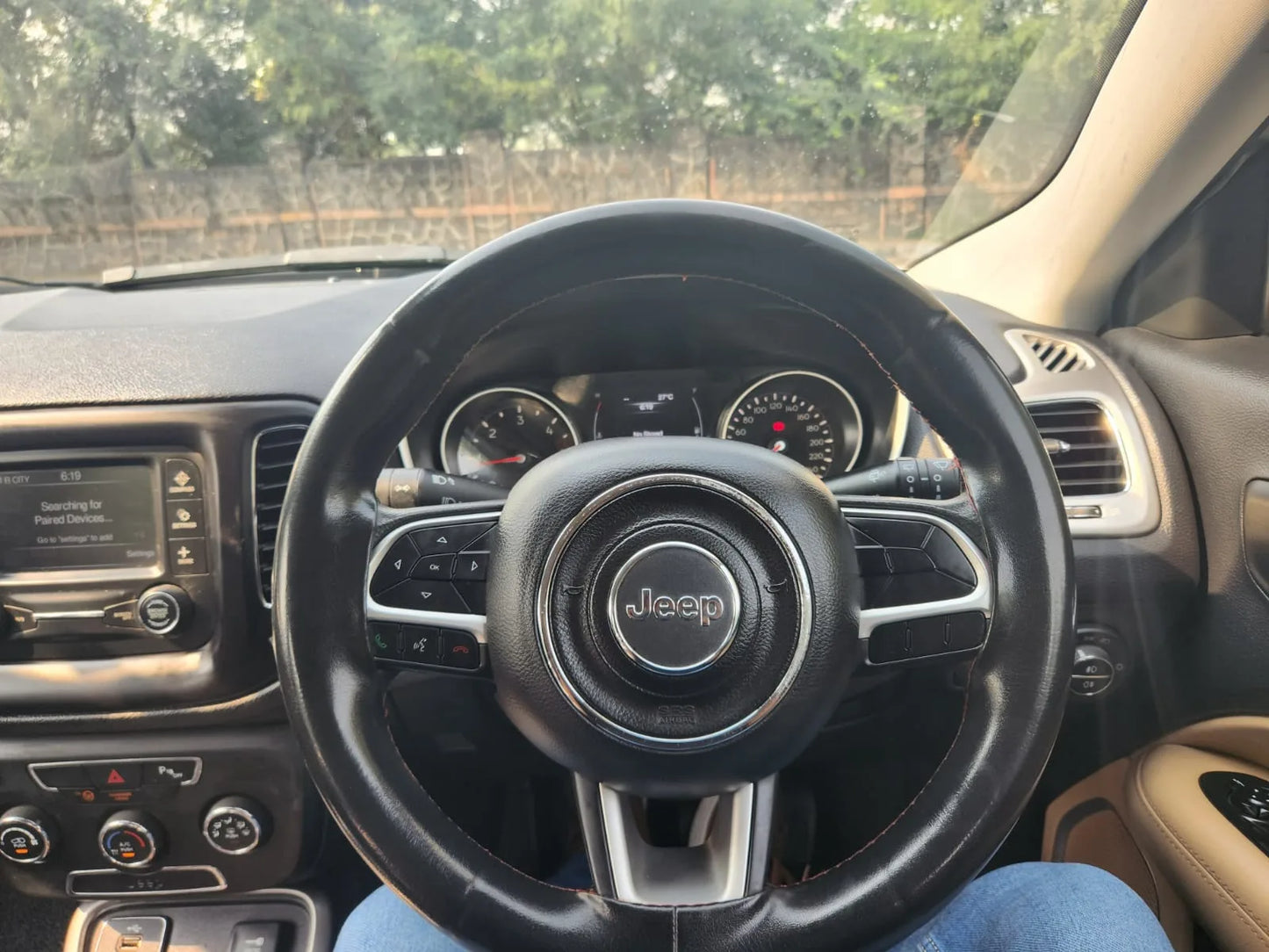 Steering wheel of a Jeep vehicle with dashboard in the background