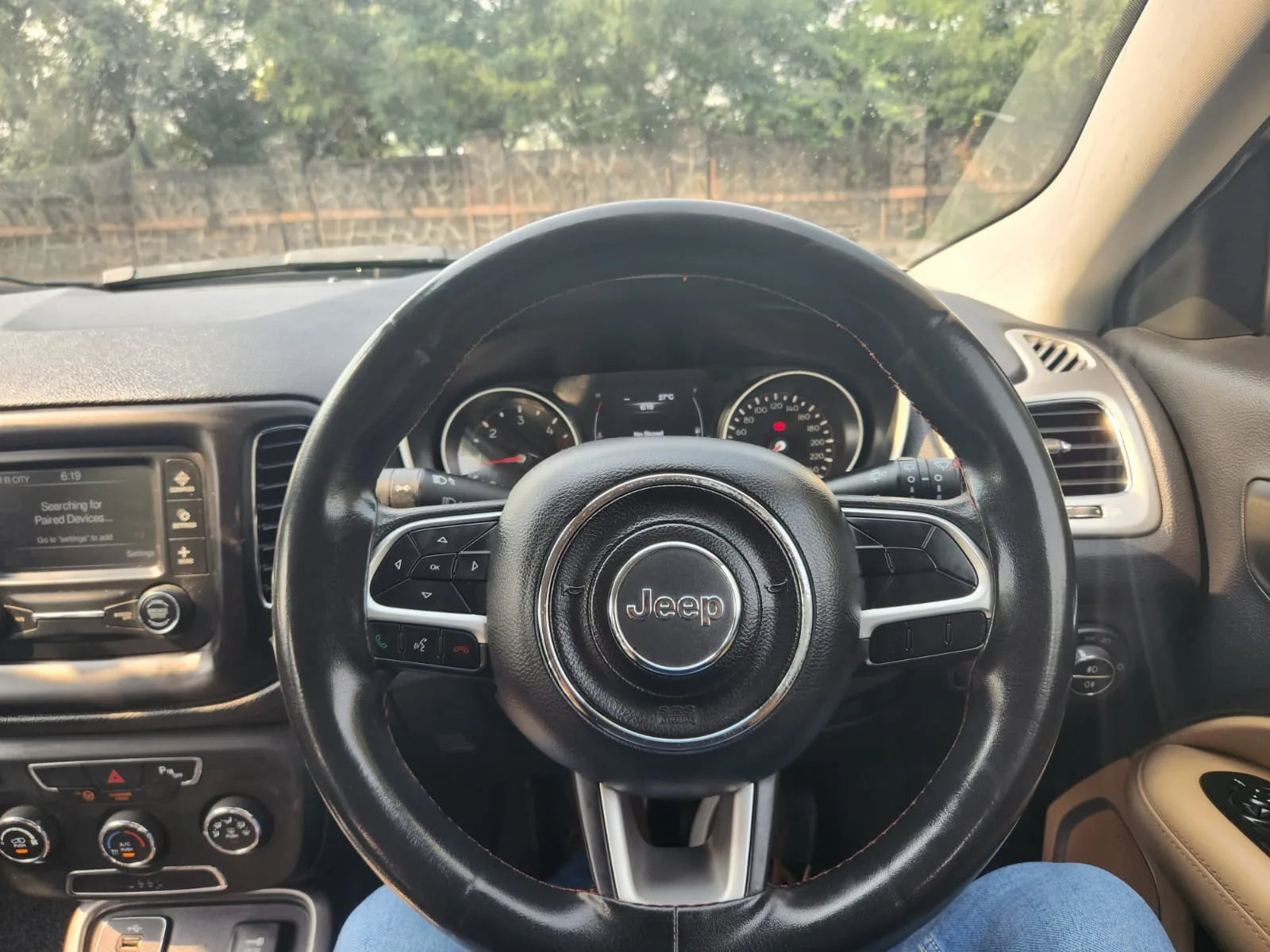 Steering wheel of a Jeep vehicle with dashboard in the background