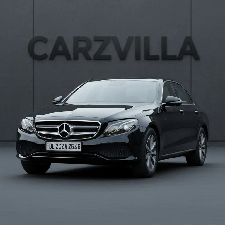 Black Mercedes-Benz car in front of a gray wall with 'CARZVILLA' branding.