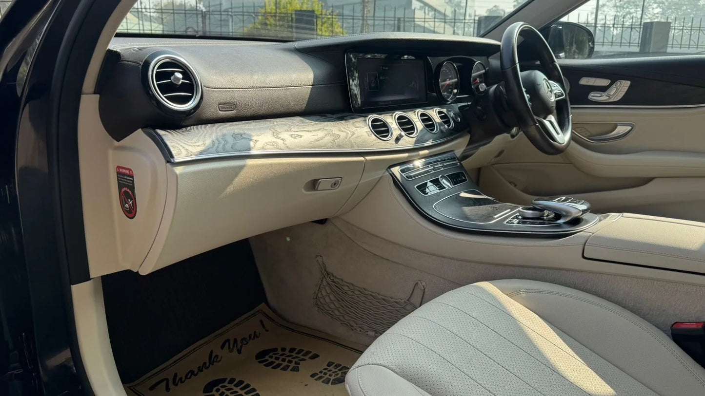 Luxury car interior with beige leather seats and dashboard.