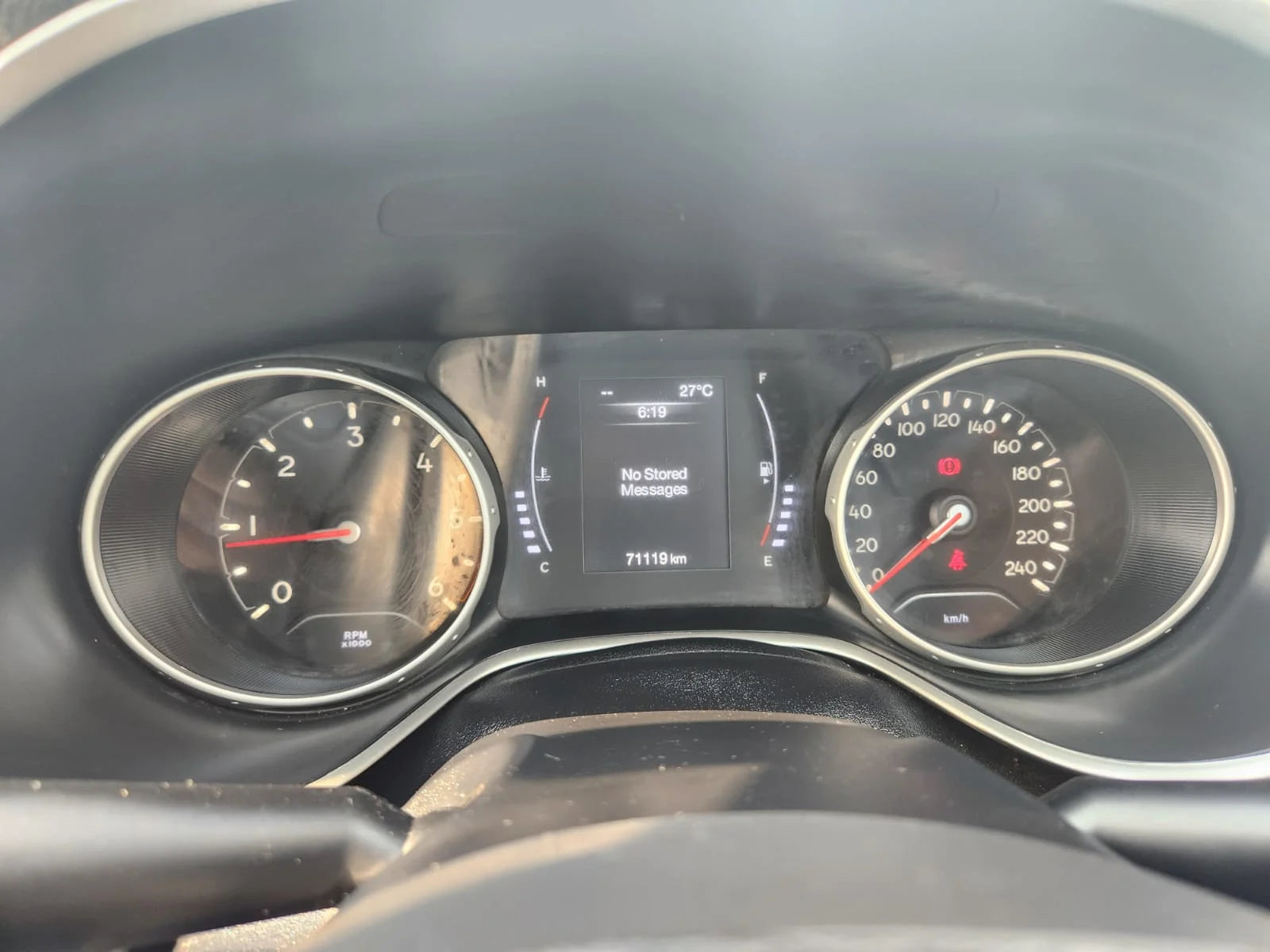 Car dashboard with speedometer and digital display showing temperature and other metrics.
