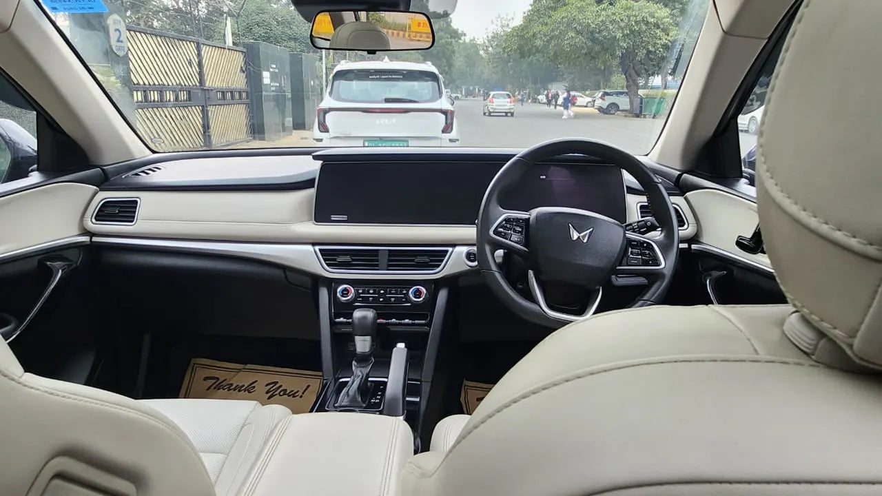 Car interior with dashboard, steering wheel, and front seats.