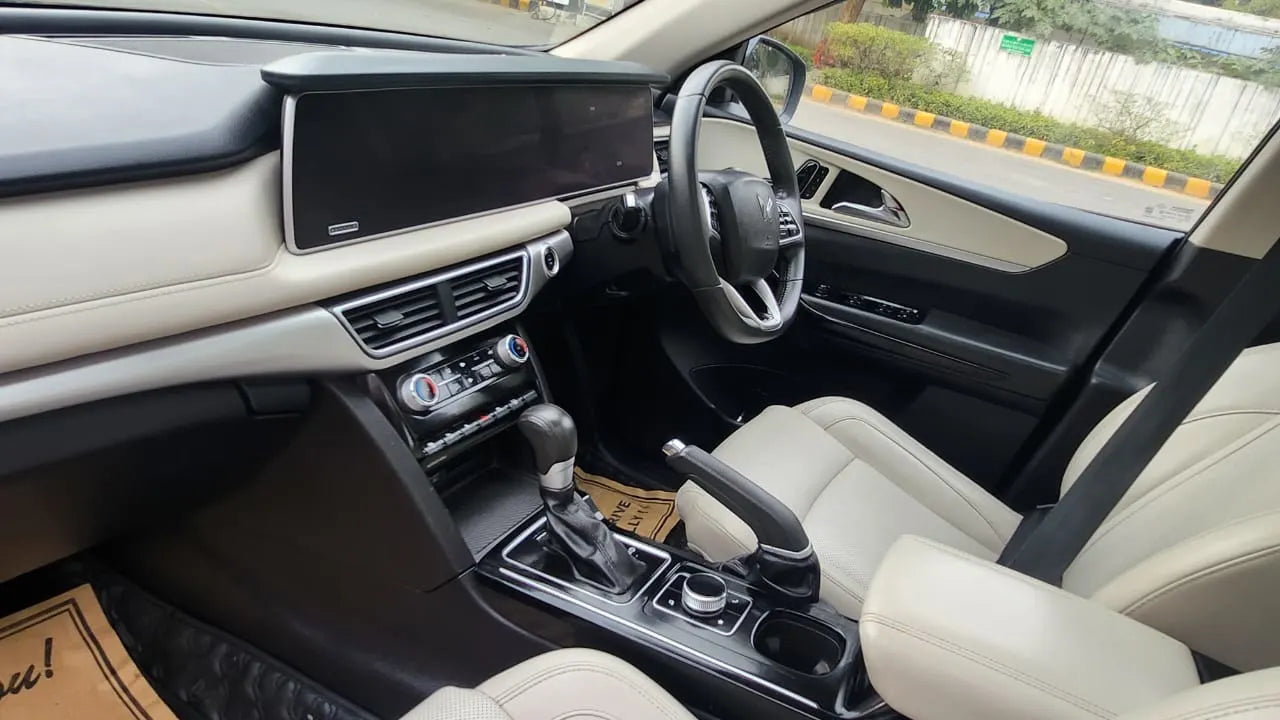 Car interior with dashboard, steering wheel, and seats.