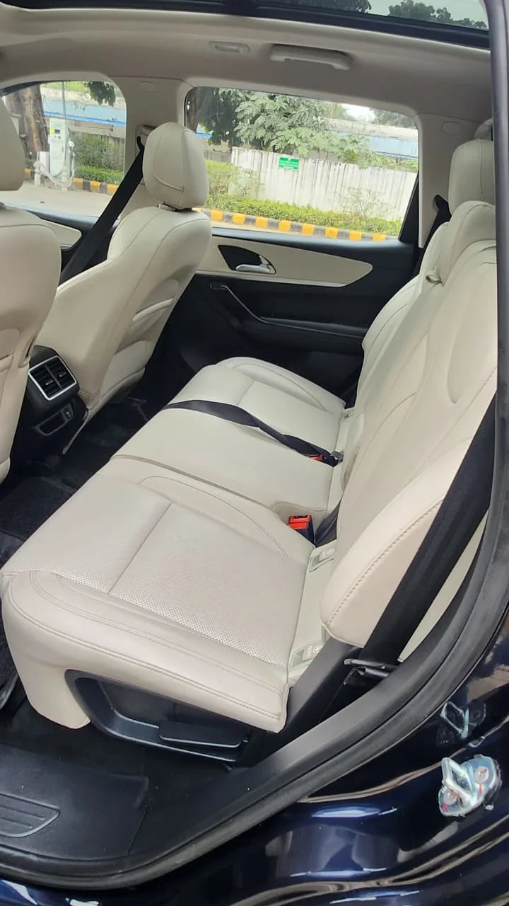 Beige car interior with visible seat belts and dashboard.